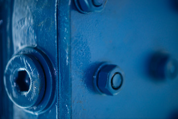 Blue metal rough surface of part with bolts and nuts. Blue painted of auto part. Automotive grunge background image.