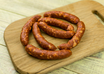 Smoked natural sausages   on a wooden surface.