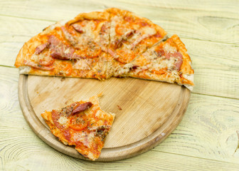 Freshly prepared homemade pizza on a wooden background.