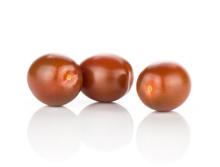 Three black red grape cherry tomatoes isolated on white background.