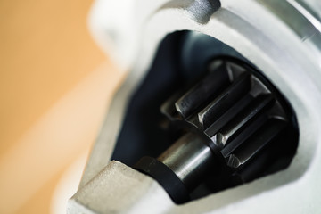 Background image of auto parts with rotor close-up. Big black pinion in metal part. Gear parts...