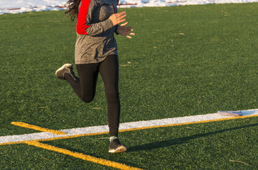 Running on a turf field with snow in the background
