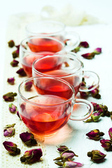 Rose tea and flower petals on white background