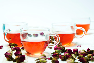 Rose tea and flower petals on white background