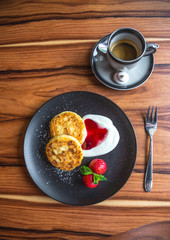 Cottage cheese pancakes. Russian syrniki with cranberry jam and yogurt, selective focus