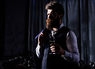 Bearded man with confident face holds champagne glass.
