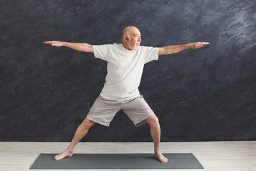 Senior man practicing yoga indoors