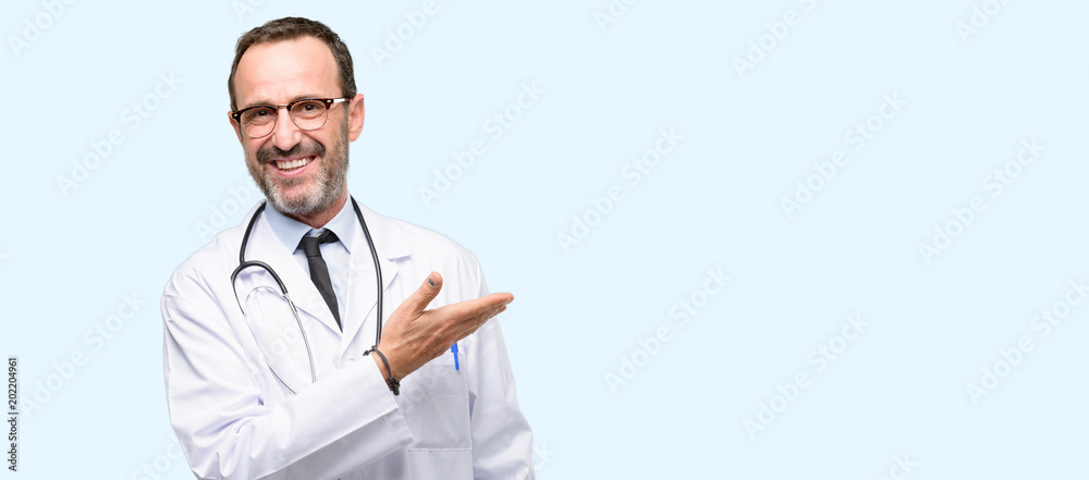 Wall mural doctor senior man, medical professional holding something in empty hand isolated over blue backgroun