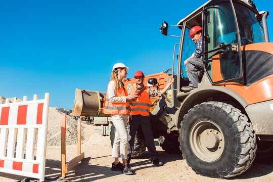 Drei Arbeiter auf einer Tiefbau Baustelle 