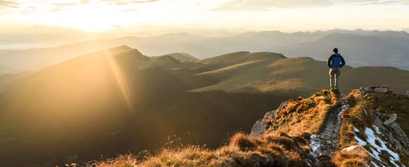 Fototapeten Silhouette des Mannes auf dem Gipfel des Berges am Sonnenaufgangshimmel, Sport und aktives Leben konzeptionelles Design. © Roman Pyshchyk