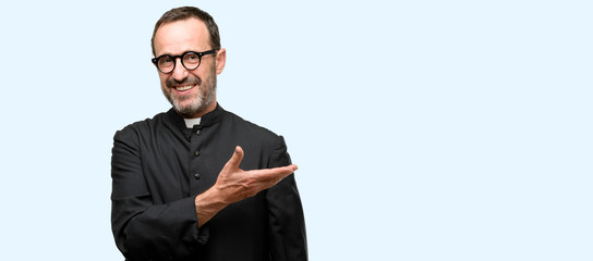 Priest religion man holding something in empty hand isolated over blue background