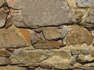 Fototapeta premium Detail of an old stone wall of a rural building, texture of natural stone
