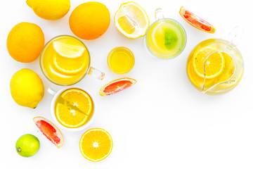 Fruit tea. Teacup and teapot among citrus on white background top view copy space