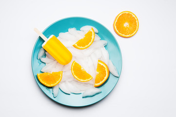 Orange popsicle on a plate of ice cubes