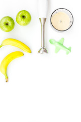 Homemade baby food. Cook puree with apple and banana with immersion blender. White background with toy top view space for text