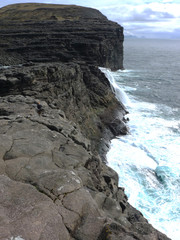 waterfall and cliffs at leitisvatn, faroe islands