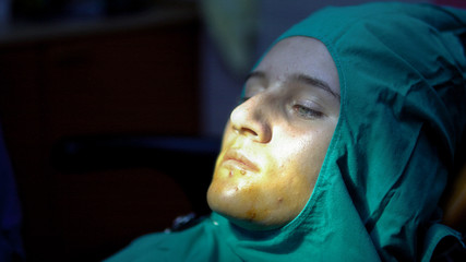 Girl at Tooth, Gum, Oral surgery, apicectomia in dark operation room