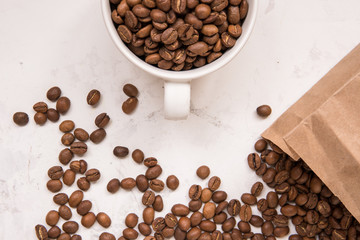 Coffee beans in a cup on a white table