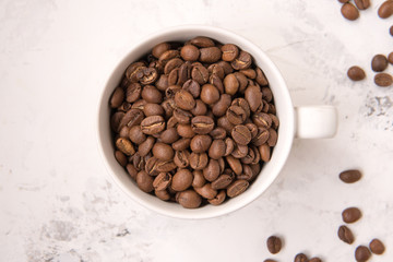 Coffee beans in a cup on a white table