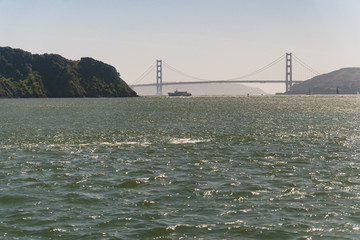 Golden Gate Bridge and small boats as seen from a ferry on the San Francisco Bay in late afternoon