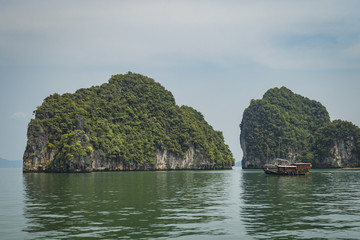 Fototapeta na wymiar Boat by islands in Thailand