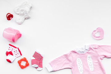 Newborn baby's background. Clothes for small girl with booties on white top view copy space