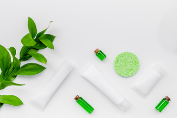 Organic skin care products. Cream, lotion, tonic. oil near green leaves on white background top view pattern