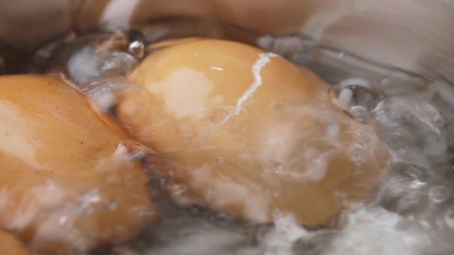 Chicken eggs boiling in stainless steel pan