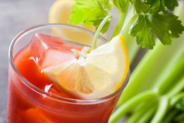 Bloody Mary cocktail in glass on wooden table.