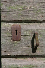 Wooden old vintage door with rusty iron keyhole and handle