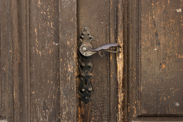 Antique metal door handle on old wooden doors. Vintage iron door knob.