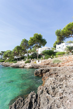 Cala d'Or, Mallorca - A rocky coastline and and beautiful trees at the beach of Cala d'Or