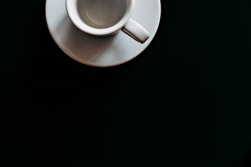 white coffee mug on black background top view