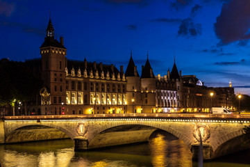 Fototapeta na wymiar Night view of Conciergerie Castle and Bridge of Change over river Seine. Paris, France