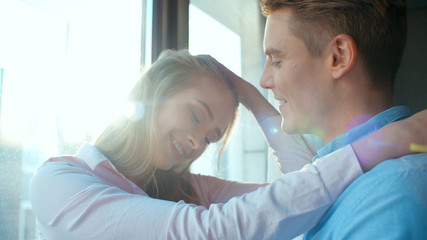 Portrait of happy couple standing together near the window.