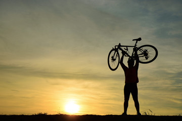 Silhouette of handsome man with bicycle on sunset,sport man concept