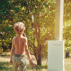 Young male athlete practicing with kunai on summer day, image with toning and square aspect ratio