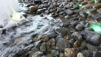 top view of background wet rolling stone colorful on the beach