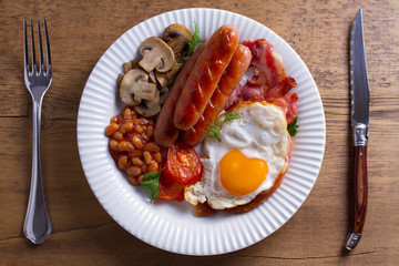 Full English or Irish breakfast: sausages, bacon, egg, mushrooms, tomatoes and beans. Nutritious morning meal
