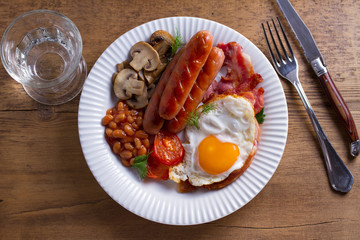 Full English or Irish breakfast: sausages, bacon, egg, mushrooms, tomatoes and beans. Nutritious morning meal