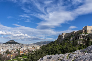 Fototapeta na wymiar Athens, Greece. Panoramic view of the city of Athens, Acropolis, Lycabettus as seen from the vantage point of Areopagus hill in Plaka. Sunny day with blue cloudy sky