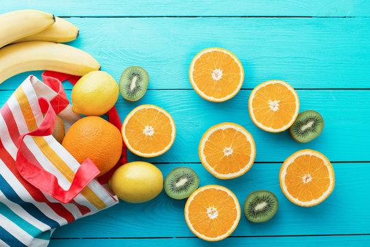 Summer fun time and fruits on blue wooden background. Mock up and picturesque. Orange, lemon, kiwi, banana fruit on table. Top view and mock up