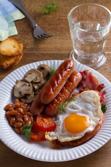 Full English or Irish breakfast: sausages, bacon, egg, mushrooms, tomatoes and beans. Nutritious morning meal