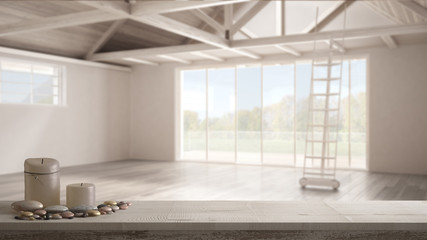 Wooden vintage table top or shelf with candles and pebbles, zen mood, over blurred mezzanine loft, empty industrial space, white architecture interior design