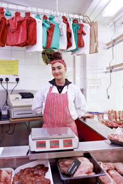 Portrait of woman behind counter in butcher's shop