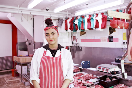 Portrait of woman wearing apron in butcher's shop