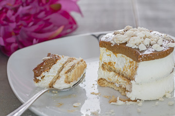 A plate with typical canarian Polvito Uruguayo dessert. Background: a pink flower.