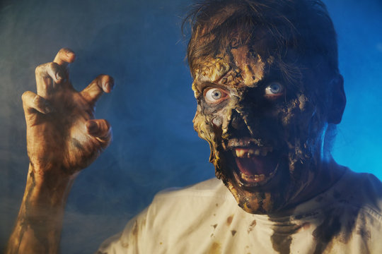 scary zombie closeup on dark background in Halloween makeup