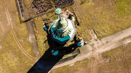 Aerial image of Ruchill Tower in Glasgow. A tall square red brick and stone Victorian water tower on a hilltop conserved after the demolition of Ruchill Hospital.