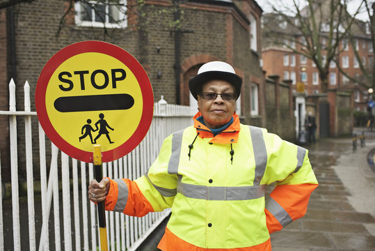 Portrait of crossing guard holding stop sign